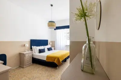 a bedroom with a bed and a vase with flowers in it at Next Stop Vatican Guest House in Rome