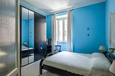 a blue bedroom with a bed and a window at Flaminio Tiepolo bright and central in Rome in Rome