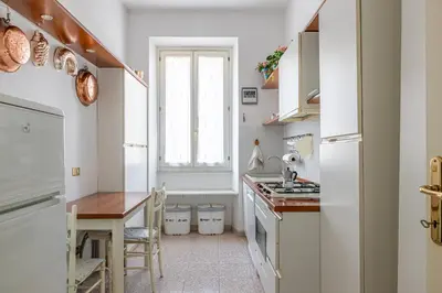 a kitchen with white cabinets and a table and a window at Flaminio Tiepolo bright and central in Rome in Rome