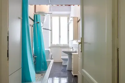 a bathroom with a blue shower curtain and a sink at Flaminio Tiepolo bright and central in Rome in Rome