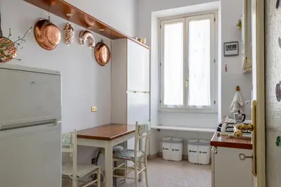 a kitchen with a table and a refrigerator and a window at Flaminio Tiepolo bright and central in Rome in Rome