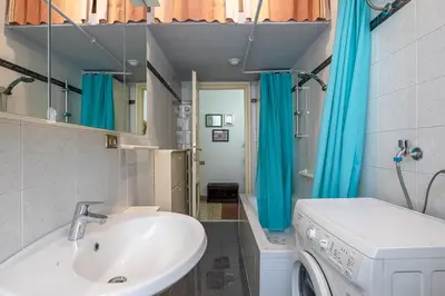 a bathroom with a sink and a washing machine at Flaminio Tiepolo bright and central in Rome in Rome