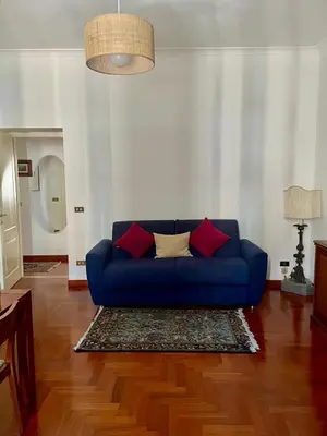a living room with a blue couch and red pillows at Testaccio 100 in Rome