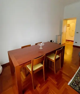 a wooden table with chairs and a wine glass on it at Testaccio 100 in Rome