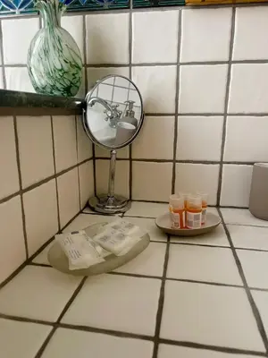a bathroom counter with a mirror and a plate of cosmetics at Testaccio 100 in Rome