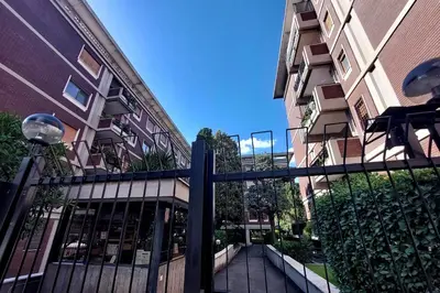 a fence in front of a building next to a building at Fossato Di Vico in Rome