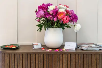 a vase of flowers sitting on top of a table at Petra Apartments San Giovanni in Rome