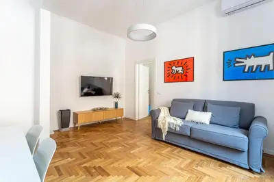 a living room with a blue couch and a tv at iFlat New Refined Apartment Near the Vatican in Rome