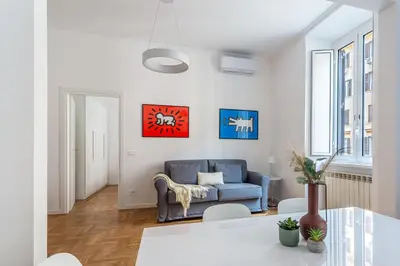 a living room with a blue couch and a table at iFlat New Refined Apartment Near the Vatican in Rome