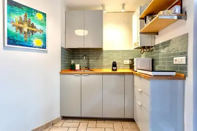 a kitchen with white cabinets and a painting on the wall at San Lorenzo Studio Flat in Rome