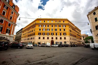a yellow building with cars parked in front of it at San Lorenzo Studio Flat in Rome