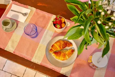 a table with a plate of pastry and a bowl of fruit at San Lorenzo Studio Flat in Rome