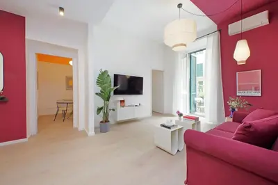 a living room with red walls and a pink couch at Elegance in Parioli Rome La casa di Pigi in Rome