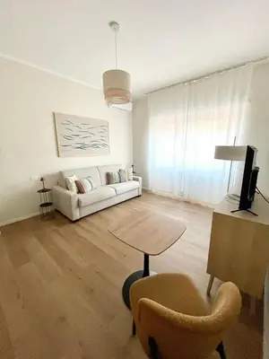 a living room with a white couch and a table at Bonci Rooms - Appartamento in zona Policlinico Gemelli, Università Cattolica, Vaticano, Stadio Olimpico in Rome