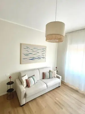 a living room with a white couch and a painting at Bonci Rooms - Appartamento in zona Policlinico Gemelli, Università Cattolica, Vaticano, Stadio Olimpico in Rome