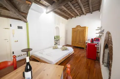 a bedroom with a bed and a table in a room at Trastevere Romantic Nest in Rome