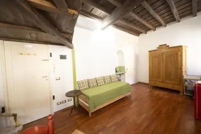 a bedroom with a green bed and a wooden floor at Trastevere Romantic Nest in Rome