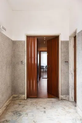 an empty hallway with a wooden door in a building at Vatican Loft - Mura Vaticane in Rome