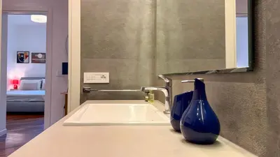 two blue vases sitting on a sink in a bathroom at Elegant Roman Escape Walk to the Colosseum in Rome