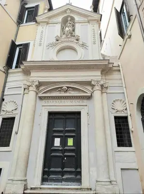 a tall white building with a black door at Library's House in Rome