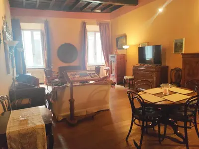 a living room with a table and a tv at Library's House in Rome