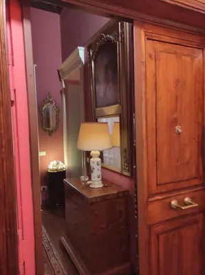 a room with a lamp on a dresser and a mirror at Library's House in Rome