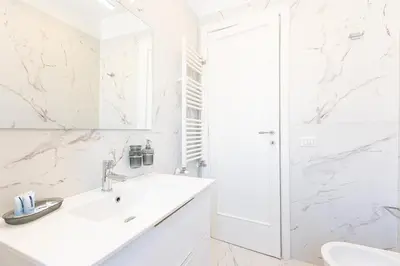 a white bathroom with a sink and a shower at Constance Apartment by Rental in Rome in Rome