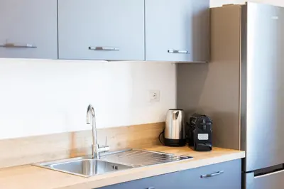 a kitchen with a sink and a refrigerator at Constance Apartment by Rental in Rome in Rome