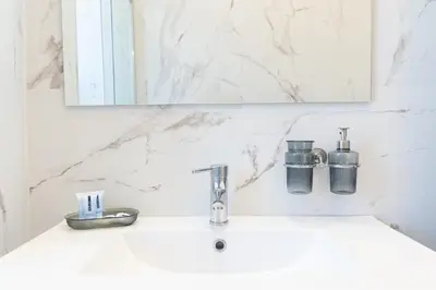 a white bathroom with a sink and a mirror at Constance Apartment by Rental in Rome in Rome
