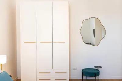 a bedroom with a mirror and a chair at Constance Apartment by Rental in Rome in Rome