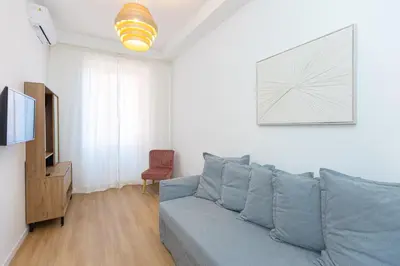 a living room with a blue couch and a television at Constance Apartment by Rental in Rome in Rome