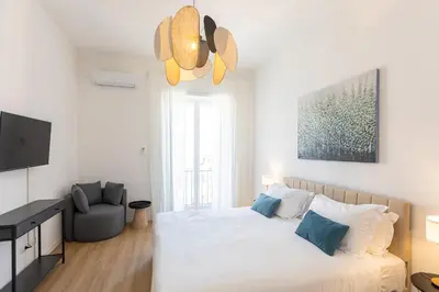 a white bedroom with a bed and a chair at Constance Apartment by Rental in Rome in Rome