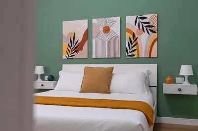 a bedroom with a bed with three pictures on the wall at City Comfort - 20 minutes walk to the Colosseum in Rome