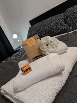 a pile of towels and a flower on a bed at Casa Vacanze Kokoroma Cipro al Vaticano in Rome