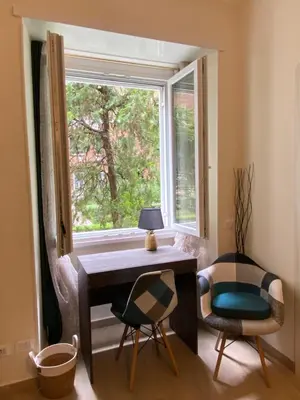 a desk and chairs in a room with a window at Gentile RHome Apartment, casa vacanze in Rome