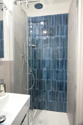 a bathroom with a shower with blue tiles at 1886 Colosseo Suite in Rome