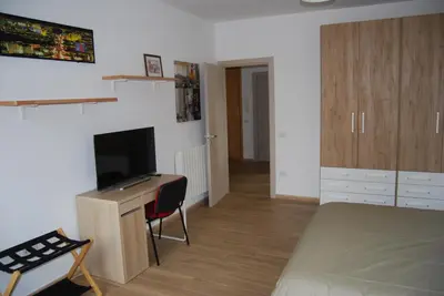 a bedroom with a bed and a desk with a television at Tiburtina Family Apartment in Rome