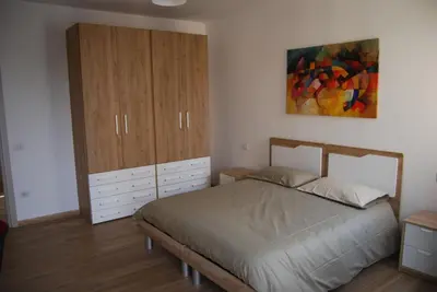 a bedroom with a bed and a cabinet and a painting at Tiburtina Family Apartment in Rome