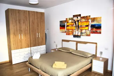 a bedroom with a bed and a painting on the wall at Tiburtina Family Apartment in Rome