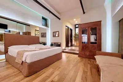 a large bedroom with a large bed and a wooden floor at Roma Suite Loft in Rome