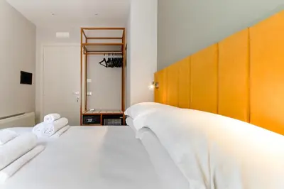a bedroom with a large bed with white sheets at Velia Relais in Rome