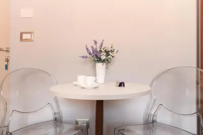a white table with two chairs and a vase of flowers at Velia Relais in Rome