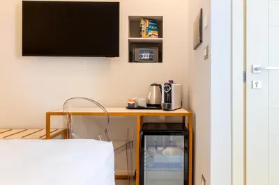 a room with a desk with a tv on a wall at Velia Relais in Rome