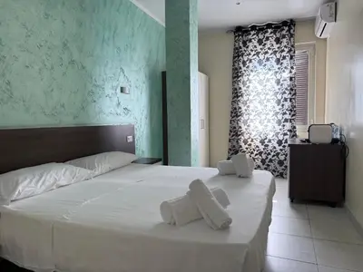 a bedroom with a large white bed with towels on it at Tiburtina Hotel Holiday in Rome