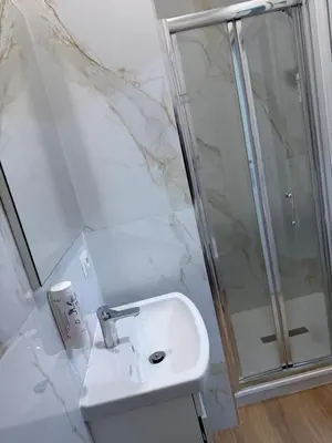a white bathroom with a shower and a sink at Tiburtina Hotel Holiday in Rome