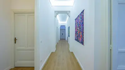 a hallway with white walls and a painting on the wall at Domus Re di Roma Design Suite in Rome