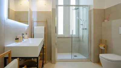 a bathroom with a shower and a sink and a toilet at Domus Re di Roma Design Suite in Rome