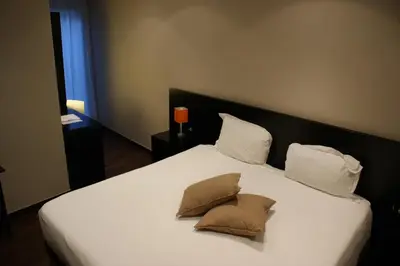 a large white bed with two pillows on it at Hotel Aniene in Rome
