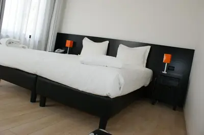 a bedroom with a large bed with white sheets and pillows at Hotel Aniene in Rome