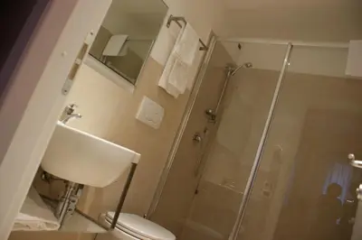 a bathroom with a shower and a toilet and a sink at Hotel Aniene in Rome